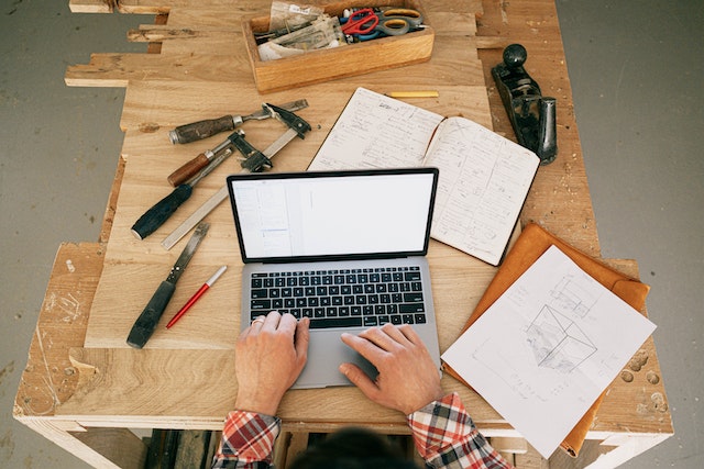 person working on a laptop at a maintenance and repair work station
